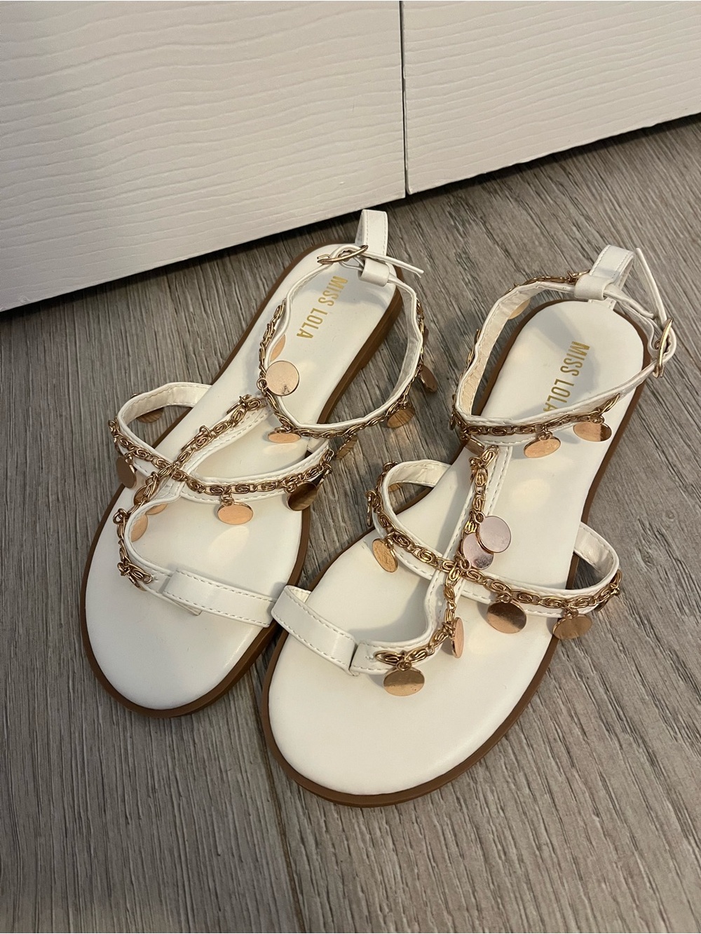 Miss Lola White T-Strap Sandals with Gold Coin Accents